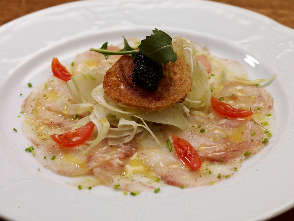 Carpaccio di cernia con insalata di finocchi, blinis di grano saraceno e caviale di aringa
