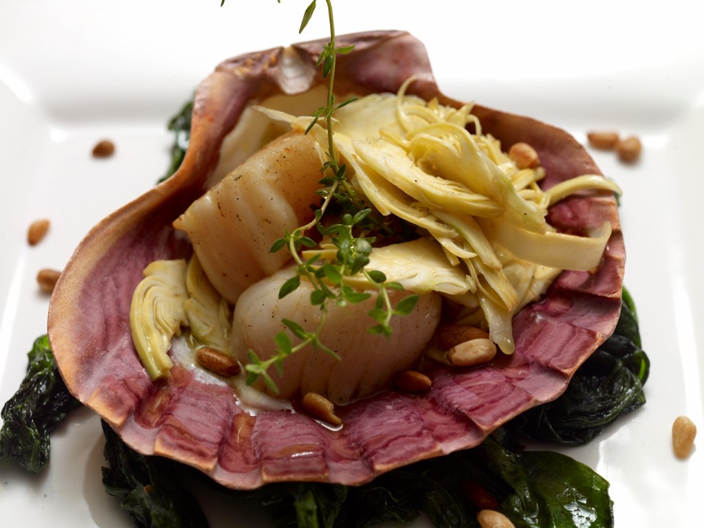 Cappesante scottate con spinaci saltati, insalatina di carciofi e pinoli tostati